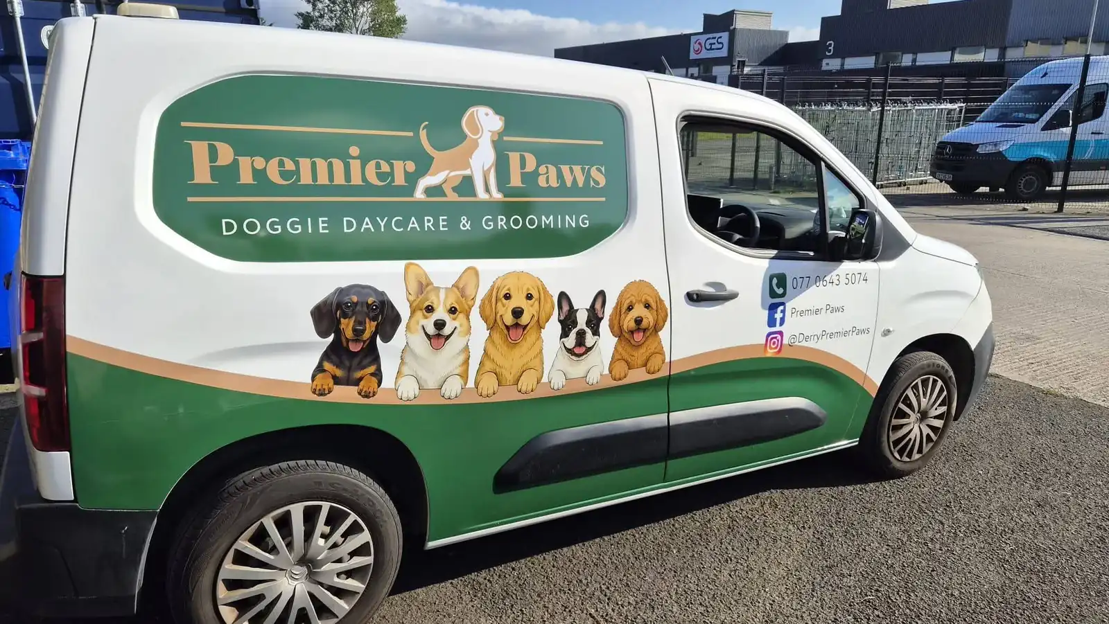 The green and white Premier Paws van, with five cartoon dogs along its side